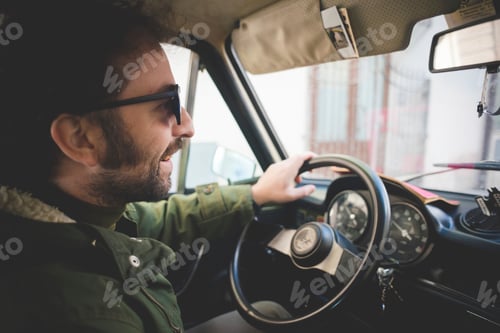 Preview: Mid adult man smiling whilst driving vintage car