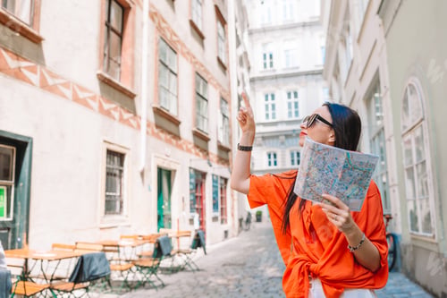 Preview: Young woman with a city map in city. Travel tourist girl with map in Vienna outdoors during holidays