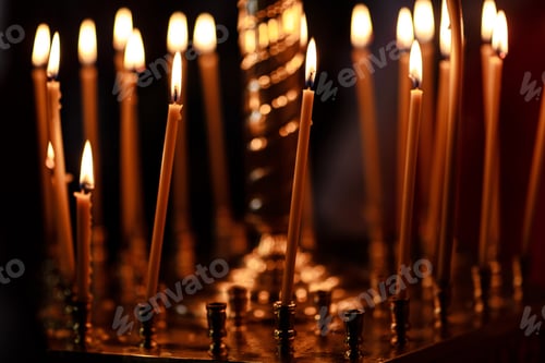 Preview: burning candles in church on dark background