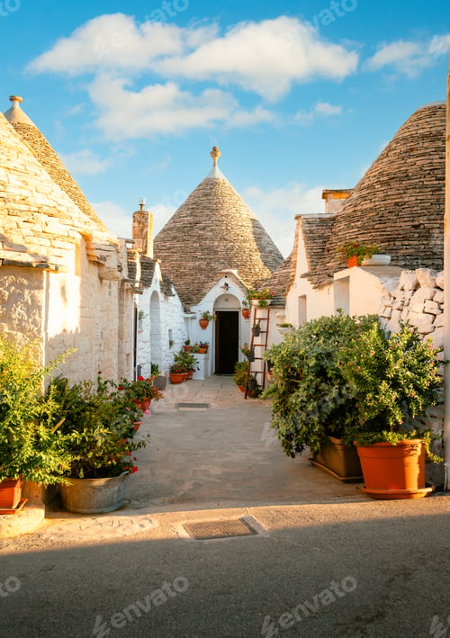 Preview: Characteristic Alberobello trullo by day, blue sky with clouds, vertical