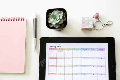 Preview: Desktop flat lay with monthly calendar on tablet and supplies on white background