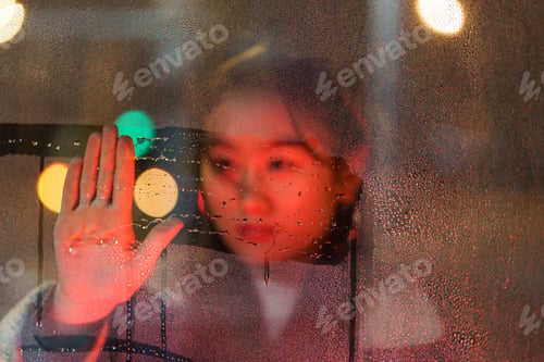 Preview: Anxious millennial woman drawing on wet window glass suffer from partner loss or crisis in marriage