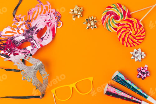 Preview: flat lay with lollipops and party objects isolated on orange, purim holiday concept