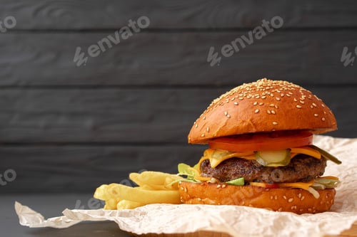 Preview: Fresh burger and fries on black wooden background