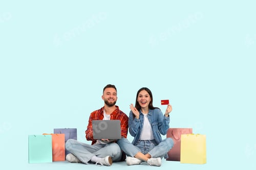Preview: Young couple shopping online with card on blue background
