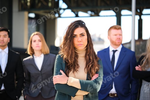 Preview: Business woman manager CEO and her team serious looking at camera.