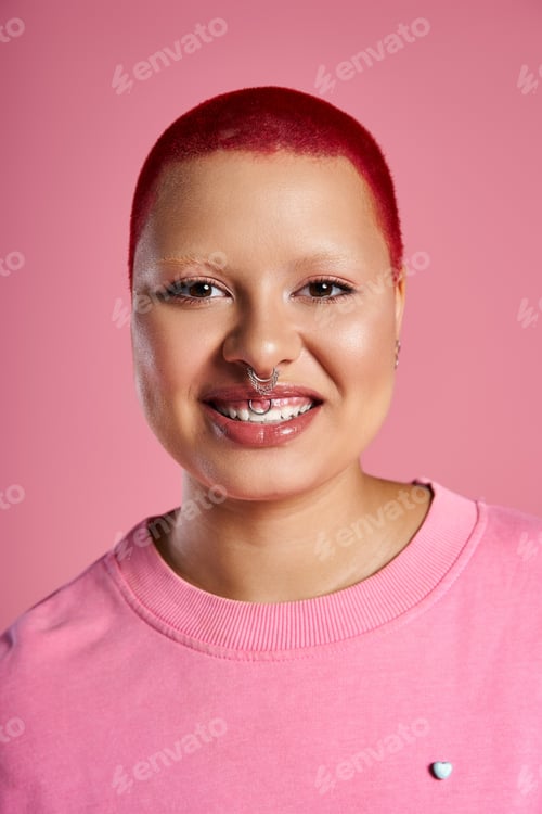 Preview: A young woman with bold pink hair and style radiates confidence in a vibrant studio space