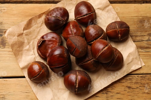 Preview: Fresh edible sweet chestnuts on wooden table, top view