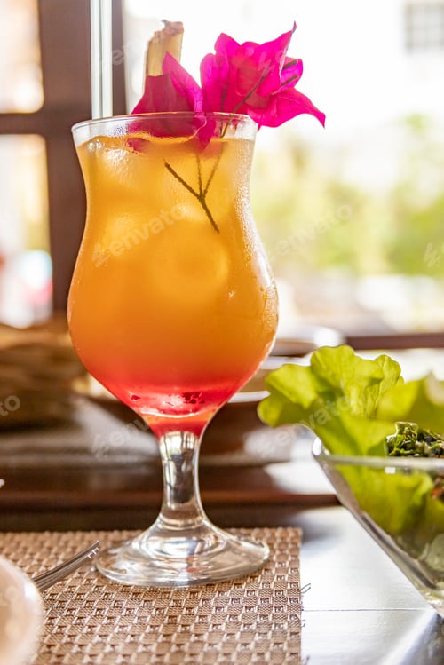 Preview: Refreshing Cocktail with Tropical Garnish on Table