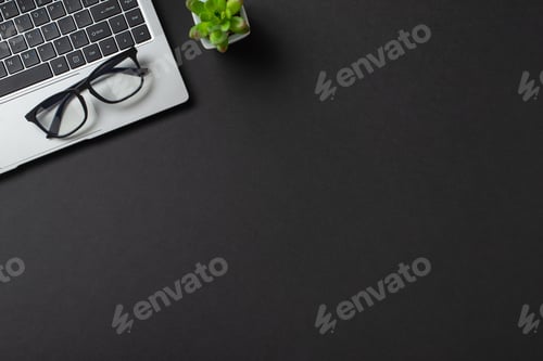 Preview: A top view of a sleek workspace featuring a laptop, glasses, and succulent on a black background