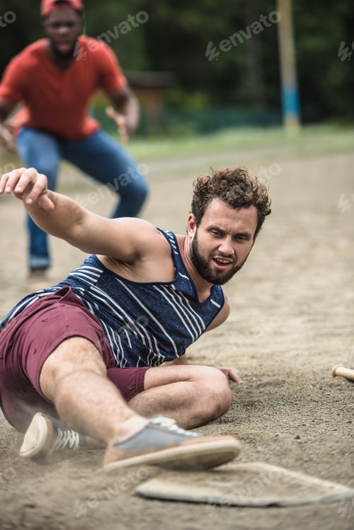 Preview: male baseball player reaching base during game on court