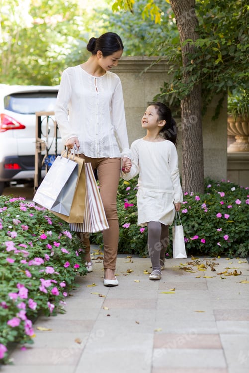 Preview: Mother and daughter walking together with shopping bags