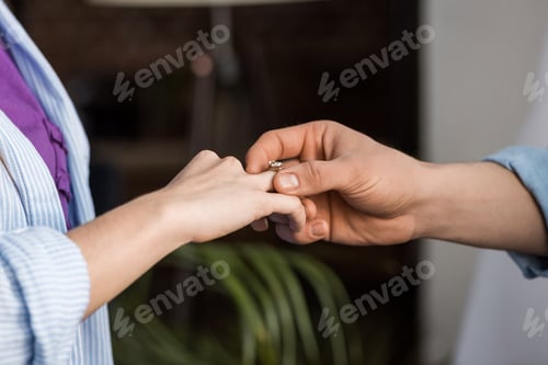 Preview: cropped image of boyfriend proposing girlfriend and wearing engagement ring