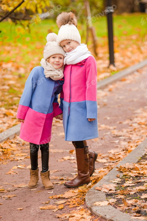 Preview: Little adorable girls outdoors at warm sunny autumn day