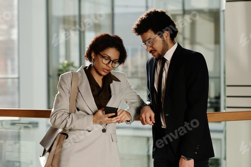 Preview: Business colleagues discussing message on smartphone