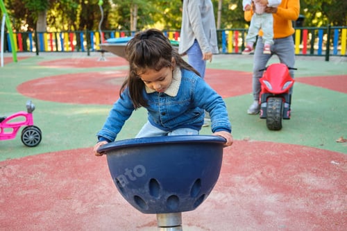 Preview: Latin boy playing spinner bowl at a playground.
