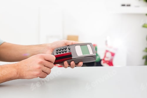 Preview: Male hands with credit card into card machine or pos terminal isolated on white background