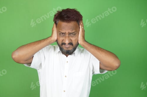 Preview: Indian adult man get nervous with his hands up on the green background
