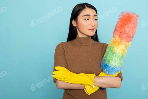 Preview: Asian janitor standing with feather duster