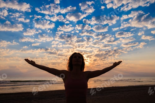 Preview: Happy woman enjoying sunrise at the beach during summer vacation