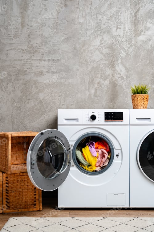 Preview: White Laundry Machines Against a Grey Concrete Wall