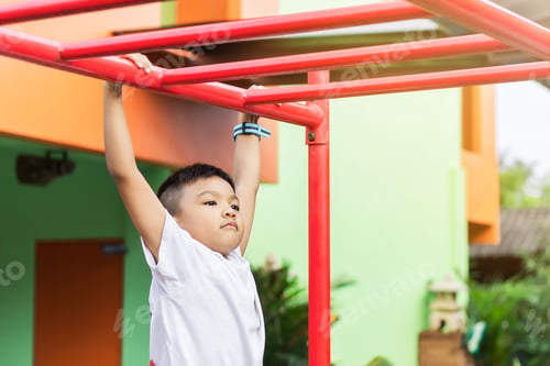 Preview: Energetic Child Playing on Red Monkey Bars Outdoors