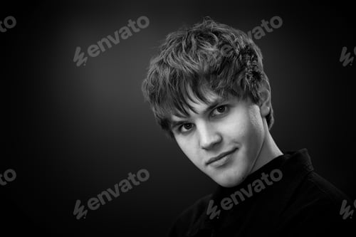Preview: positive handsome man laughing on black background