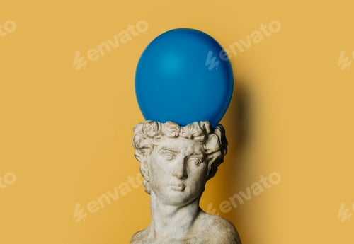 Preview: antique statue of a young man on a yellow background with a blue balloon