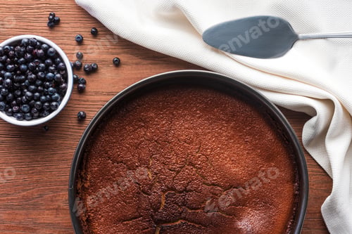 Preview: top view of delicious homemade brownie and fresh blueberries on wooden table