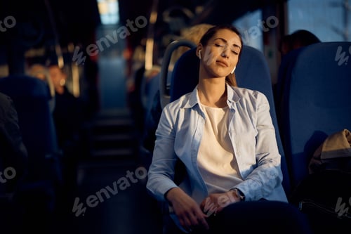 Preview: Young passenger enjoying in train ride with her eyes closed at sunset.