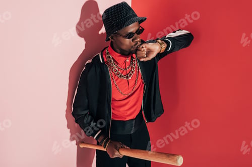 Preview: aggressive african american man in sunglasses and hat holding baseball bat
