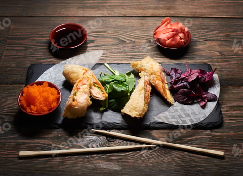 Preview: Serving sushi rolls and other traditional japanese and asian food on a table