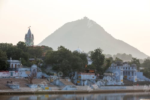 Preview: Serene riverside temples at the foot of a lush hill at dusk
