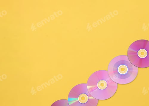 Preview: Purple compact discs forming a diagonal line on yellow background