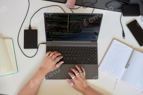 Preview: Above view of female student hands with rings on fingers using laptop