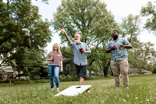 Preview: Friends playing cornhole at a summer party in the park