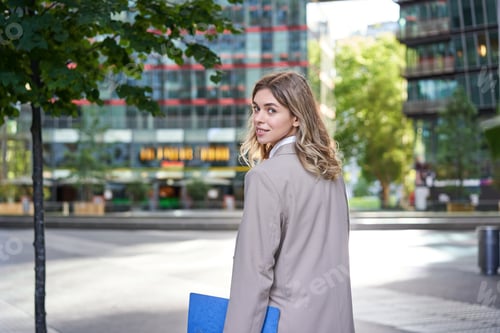 Preview: Portrait of confident saleswoman in beige suit, holding folder with work papers, turn around and