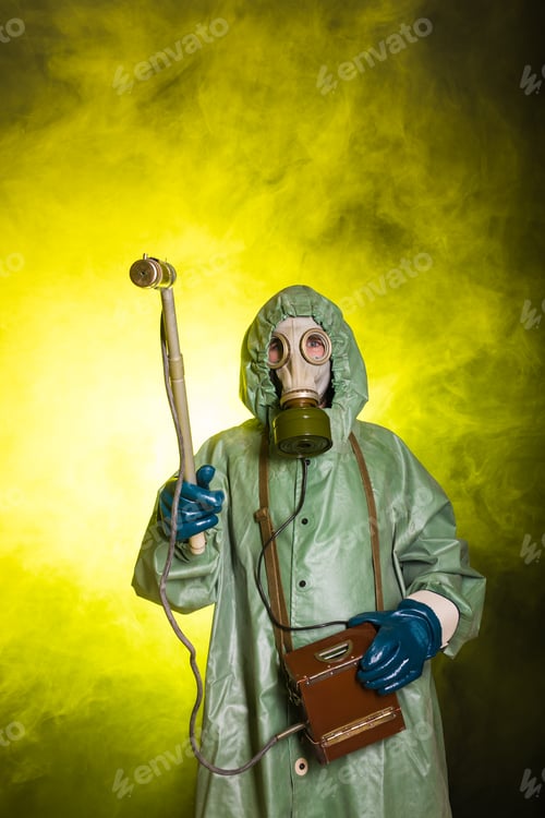 Preview: Radiation and danger concept - Man in the gas mask and chemical suit. The worker doing measure