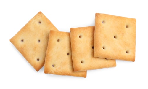 Preview: Tasty crispy square crackers isolated on white, top view