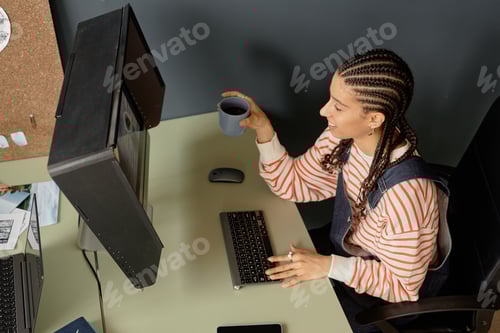 Preview: Top View of Black Woman Editing Pictures with Computer
