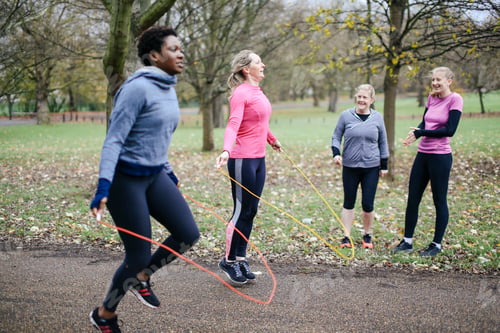 Preview: Women and teenager competing with skipping rope in park