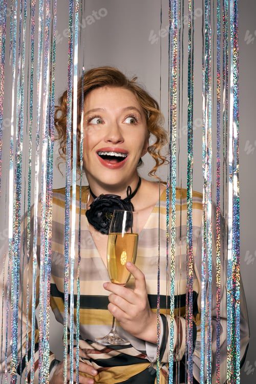 Preview: Joyful young woman enjoying a moment of celebration while gift wrapping on a festive occasion