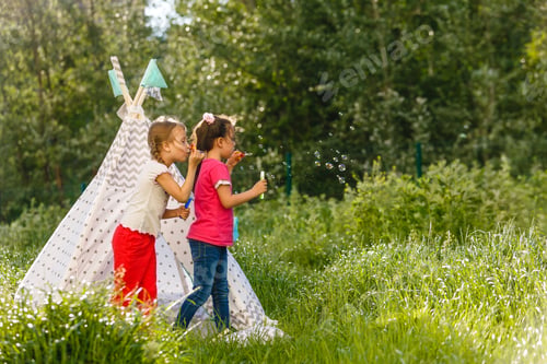 Preview: Adorable little girls having fun playing outdoors on summer day