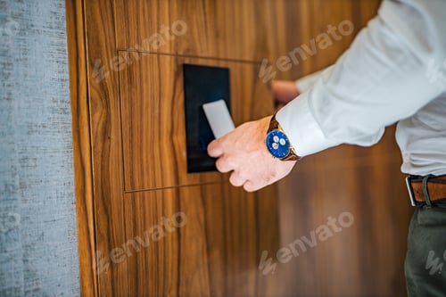 Preview: Close-up image of a businessman unlocking hotel room with a key card.