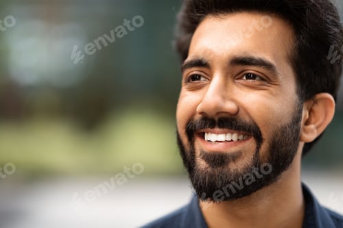Preview: Closeup of cheerful handsome indian guy looking at copy space