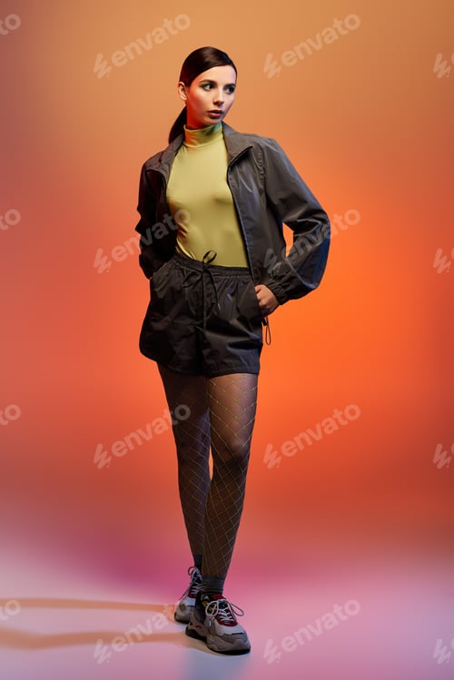 Preview: Fashion-forward young woman showcasing trendy outfit in vibrant studio setting