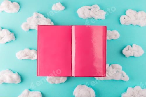 Preview: Writer desk concept. Pink open book with clouds. Top view.