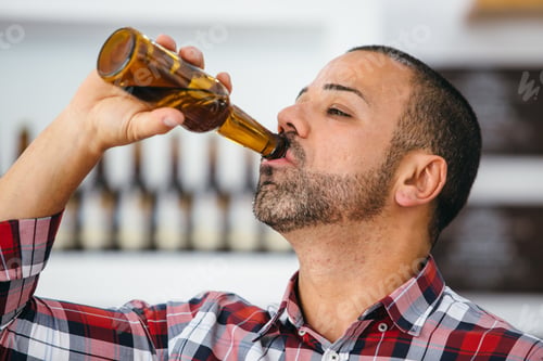 Preview: Man drinking bottled beer