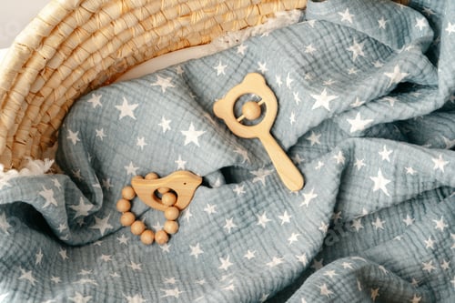Preview: Muslin blanket and wooden toys in baby cradle