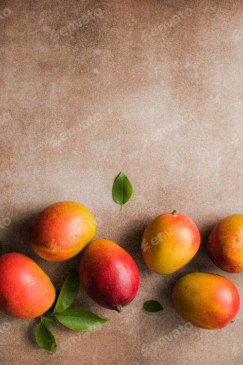 Preview: Mango background design concept. Top view of fresh mango fruit pattern with leaves on table.